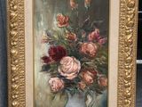 un tableau représentant des fleurs dans un vase blanc posé par terre