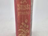 an old book sitting on top of a table next to a white wall
