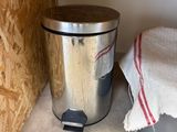 a trash can sitting on the floor next to a trash can