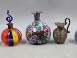 cinq vases de couleurs différentes posés les uns à côté des autres sur une table