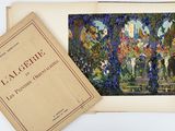 an open book sitting on top of a table next to a picture of a garden