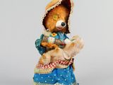 figurine représentant un ours en peluche vêtu d'une robe bleue et d'un bonnet, tenant un autre ours en peluche