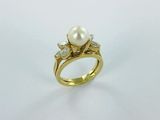 a gold ring with a pearl and diamonds