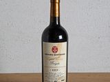 une bouteille de vin rouge posée sur une table en bois
