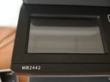 a black and white printer sitting on top of a wooden desk
