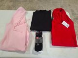 trois paires de t-shirts rouges, noirs et roses posées sur une table blanche