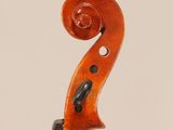 a close up of the back of a violin with a fiddle in the foreground