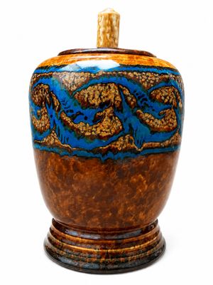 un vase marron et bleu posé sur un socle en bois