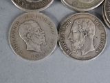 six different types of silver coins on a white surface