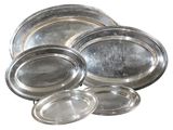 several silver plates are stacked on top of each other on a white surface