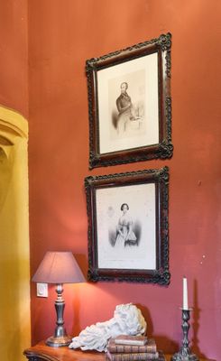 trois tableaux encadrés accrochés au mur au-dessus d'une commode