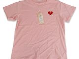 un t-shirt rose avec un cœur rouge sur la poitrine