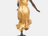 bronze statue of a woman in a flowing dress on a black base
