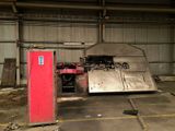 a red refrigerator sitting in a garage next to a red door