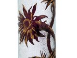 a glass vase with a flower on it on a white surface