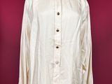 a white shirt on a mannequin stand against a red wall