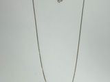 a close up of a necklace on a white surface with a white background