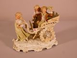 a figurine of two children riding in a horse drawn carriage