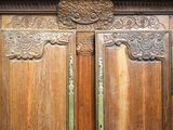 a large wooden door with carvings on the side of it