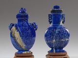 paire de vases bleus avec des anses sculptées, posés sur des socles en bois