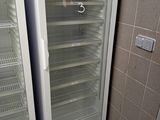 two empty refrigerators in the corner of a room