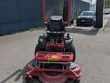 an image of a red riding mower parked in a parking lot