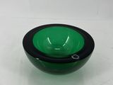 bol en verre vert et noir posé sur une surface blanche