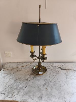une lampe posée sur une table en marbre, avec un abat-jour bleu