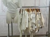 a mannequin in front of a rack of clothes
