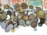 a pile of old coins and money on a white surface