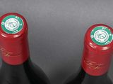 two bottles of wine sitting next to each other on a table