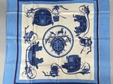 un foulard carré bleu et blanc sur lequel est représentée une calèche