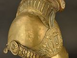 an antique helmet on a stand against a black background