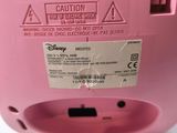 the pink machine is sitting on a white surface with a caution label