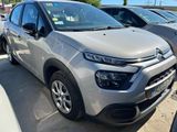 une Citroën argentée garée sur un parking à côté d'autres voitures