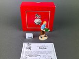 the figurine is in a red box with a card next to it