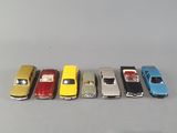 several toy cars are lined up in a row on a gray surface