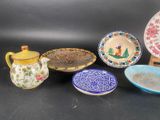 five different plates and a teapot on a table