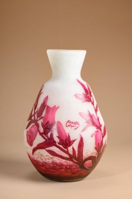 a white vase with pink flowers on it on a brown background
