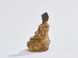 statue of a person sitting in a lotus position on a white surface