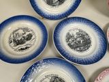 four blue and white plates with pictures of people on them