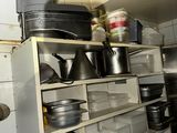 many pots and pans on a shelf in a kitchen