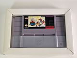 an old nintendo game in a white box on a white surface