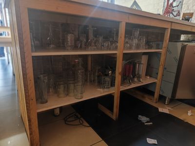 une grande étagère en bois sur laquelle sont posés de nombreux verres