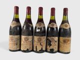 four bottles of wine are lined up in a row