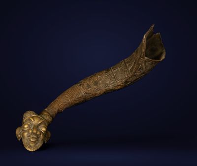 a close up of a brass pipe with a face on it