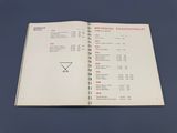 un livre ouvert sur lequel figure une liste, posé sur une table