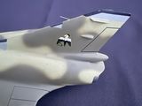 a model of a fighter jet sitting on a blue surface
