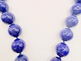 a necklace with blue beads on a white background