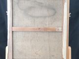 an old wooden easel with a mesh screen on top of it